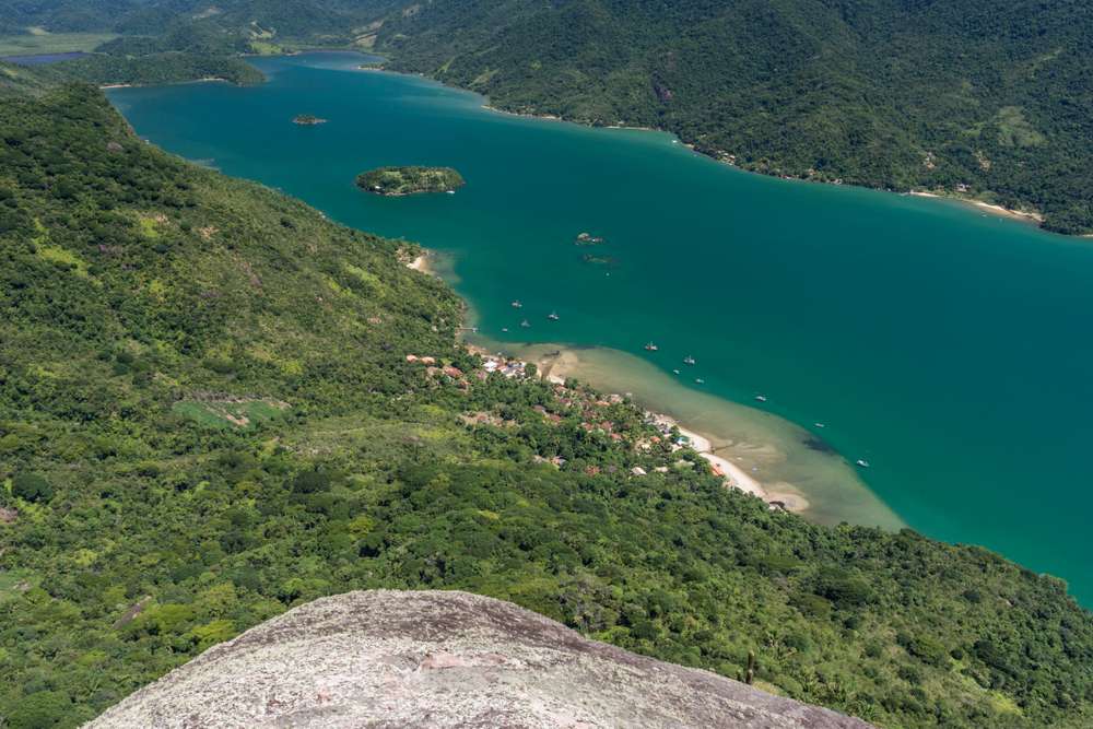 Vista do Pico do Mamangua para pequena vila de pescadores na praia da floresta tropical, Saco do Mamanguá, Paraty, Rio de Janeiro.