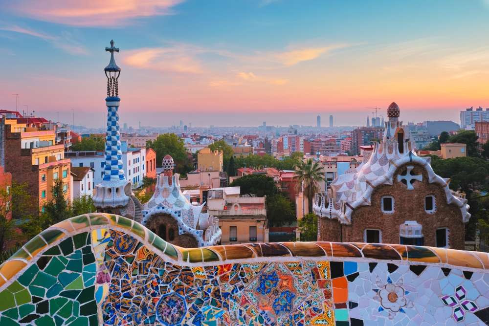 Vista da cidade de Barcelona do Parque Guell com edifícios de mosaico coloridos na atração turística Park Guell pela manhã ao nascer do sol. Barcelona, Espanha