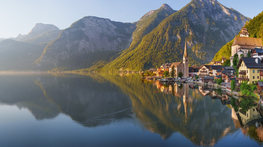 Hallstatt idílico com reflexo na água do lago - cidade velha, Áustria.
